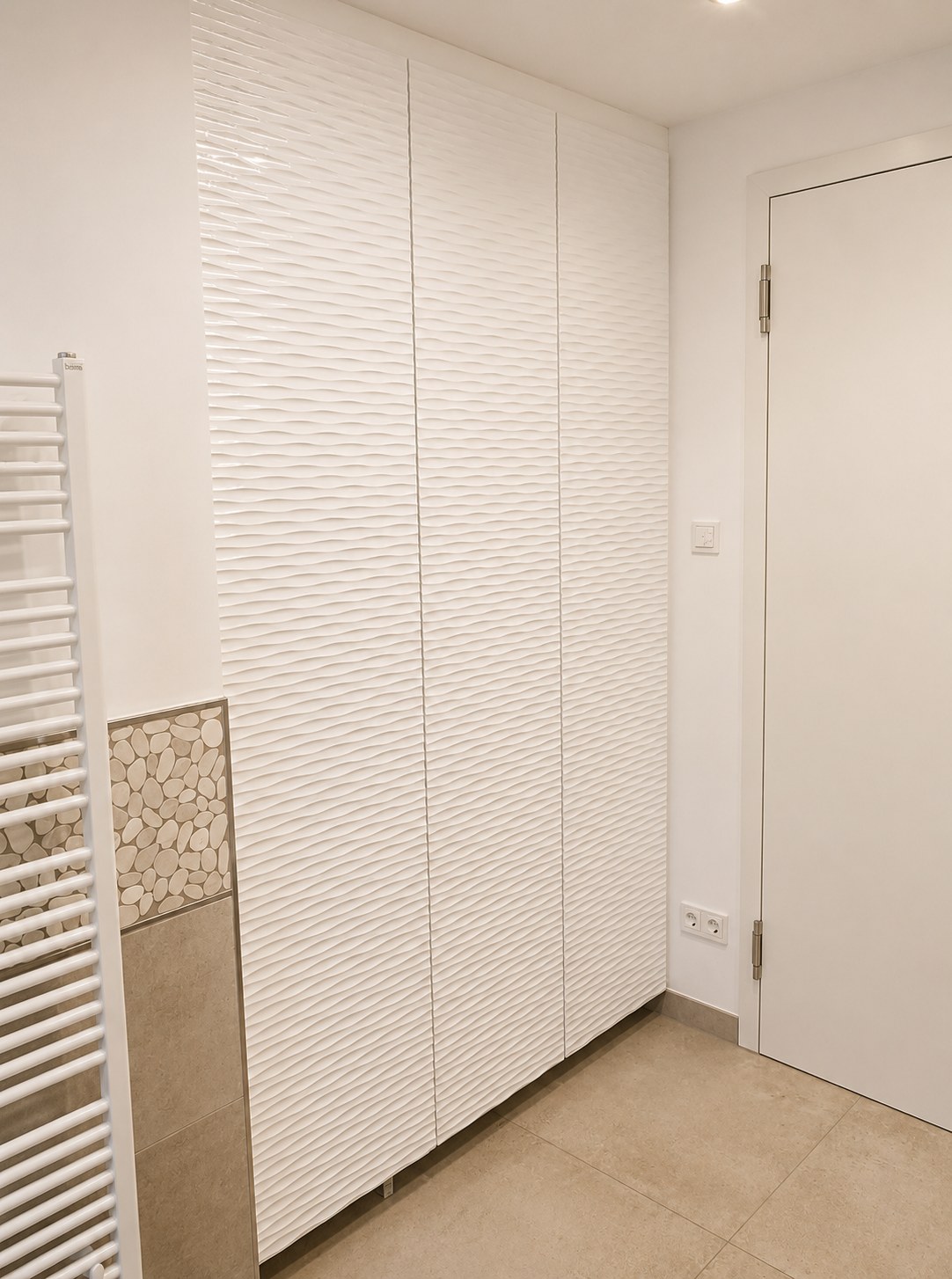 Arbi Arredobagno bathroom — tall wave column and a heated towel rail