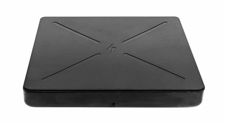 The InvisaCharge wireless charging unit from Invisacook, black and flat, with diagonal lines engraved on the top